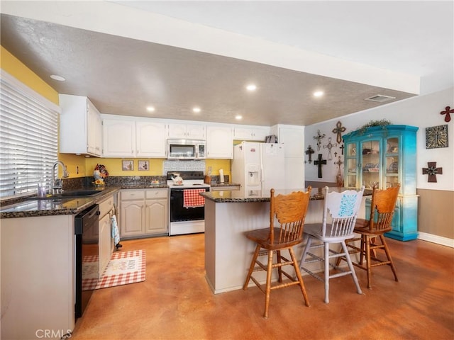27767 Hummingbird Ln, Helendale, CA 92342 - kitchen featuring white appliances, finished concrete floors, a center island, a kitchen bar, and recessed lighting