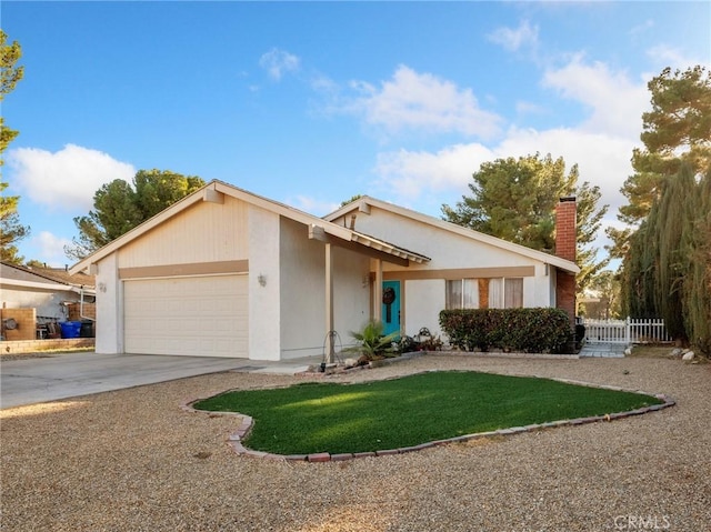 27767 Hummingbird Ln, Helendale, CA 92342 - view of front of home featuring a garage, concrete driveway, a chimney, and stucco siding