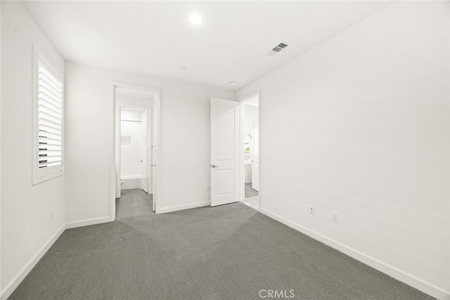 unfurnished bedroom featuring dark colored carpet