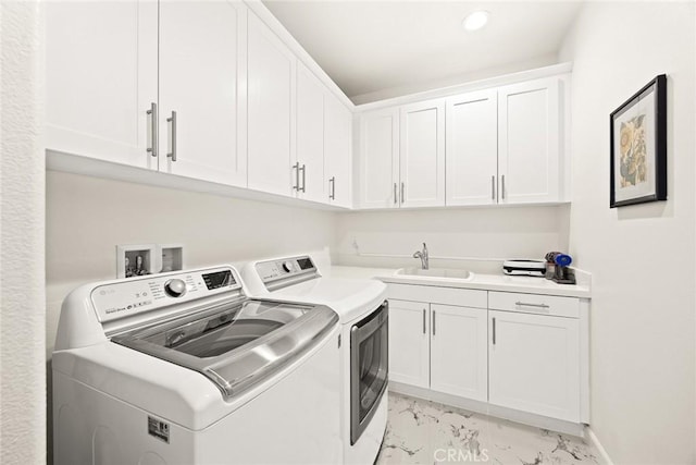 laundry area featuring sink, cabinets, and washing machine and clothes dryer