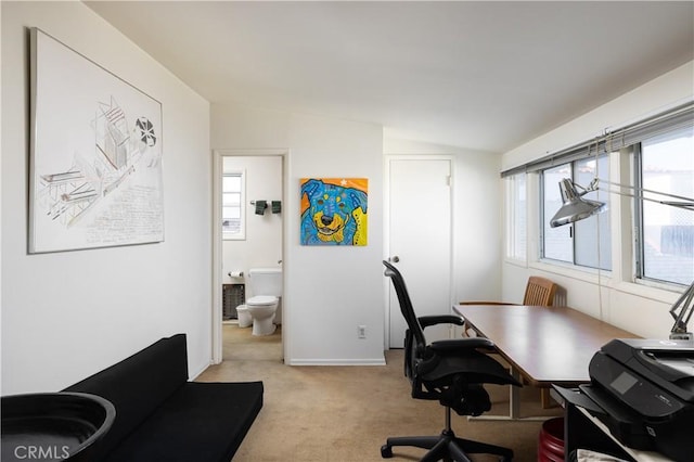 office space featuring vaulted ceiling and light colored carpet