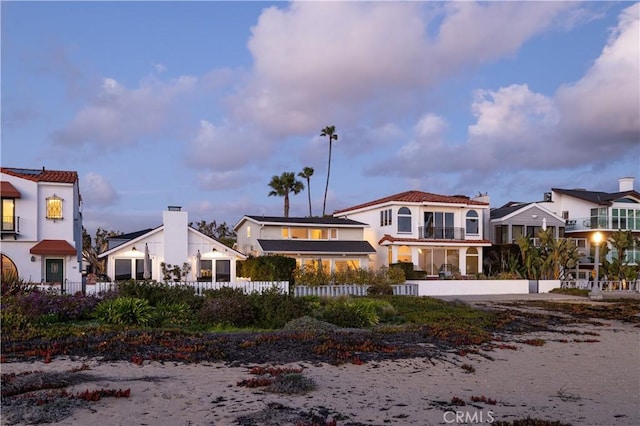 view of front facade featuring driveway, a residential view, and fence