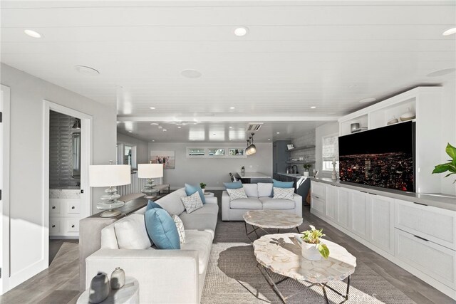 living room with dark wood-type flooring and recessed lighting