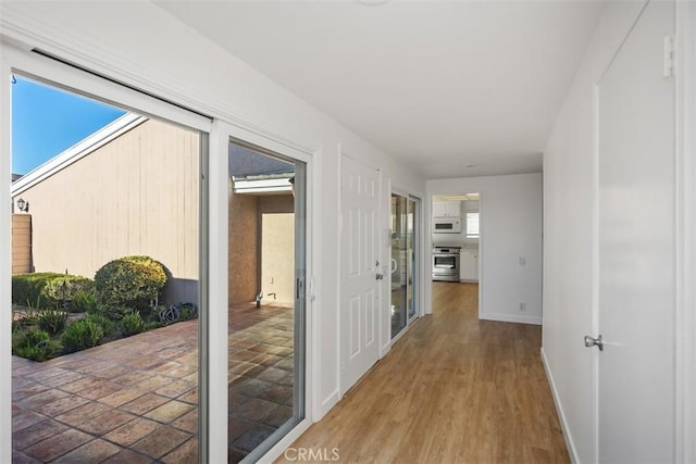 hall with baseboards and wood finished floors