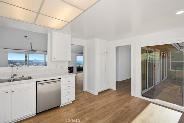 31232 Palma Dr, Laguna Niguel, CA 92677 - kitchen with dishwasher, tile counters, white cabinetry, and light wood-style floors