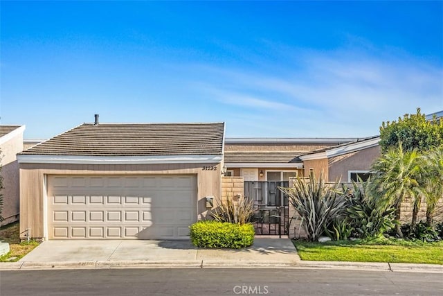 view of front of house with an attached garage, concrete driveway, and stucco siding