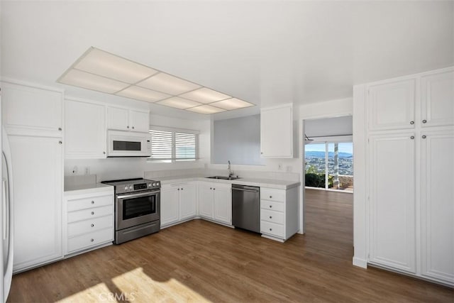 kitchen featuring plenty of natural light, white cabinets, stainless steel appliances, light countertops, and a sink