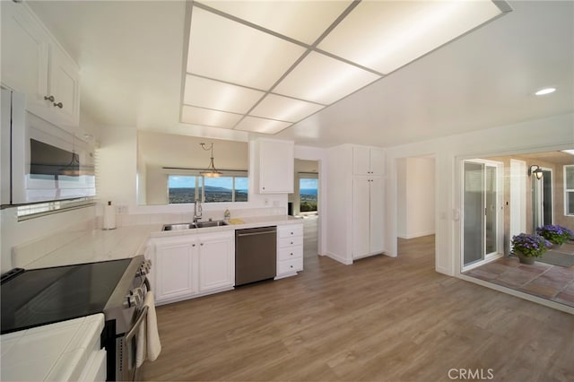31232 Palma Dr, Laguna Niguel, CA 92677 - kitchen featuring dishwasher, white microwave, electric stove, a sink, and white cabinets
