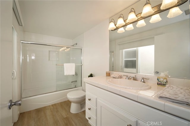 31232 Palma Dr, Laguna Niguel, CA 92677 - full bathroom featuring vanity, wood finished floors, toilet, and bath / shower combo with glass door