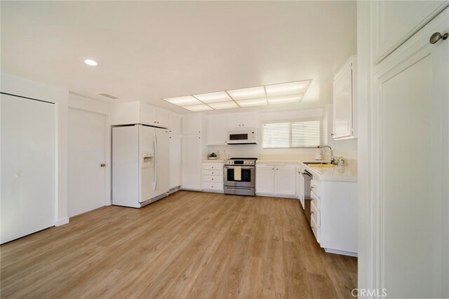 31232 Palma Dr, Laguna Niguel, CA 92677 - kitchen with white appliances, a sink, light wood-type flooring, light countertops, and white cabinets