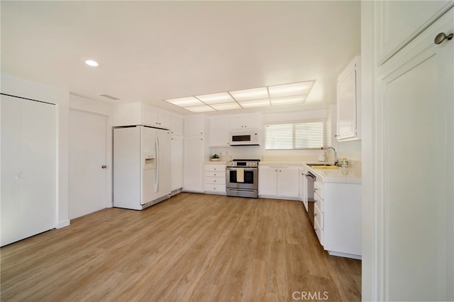 31232 Palma Dr, Laguna Niguel, CA 92677 - kitchen with white appliances, light wood-type flooring, light countertops, white cabinetry, and recessed lighting
