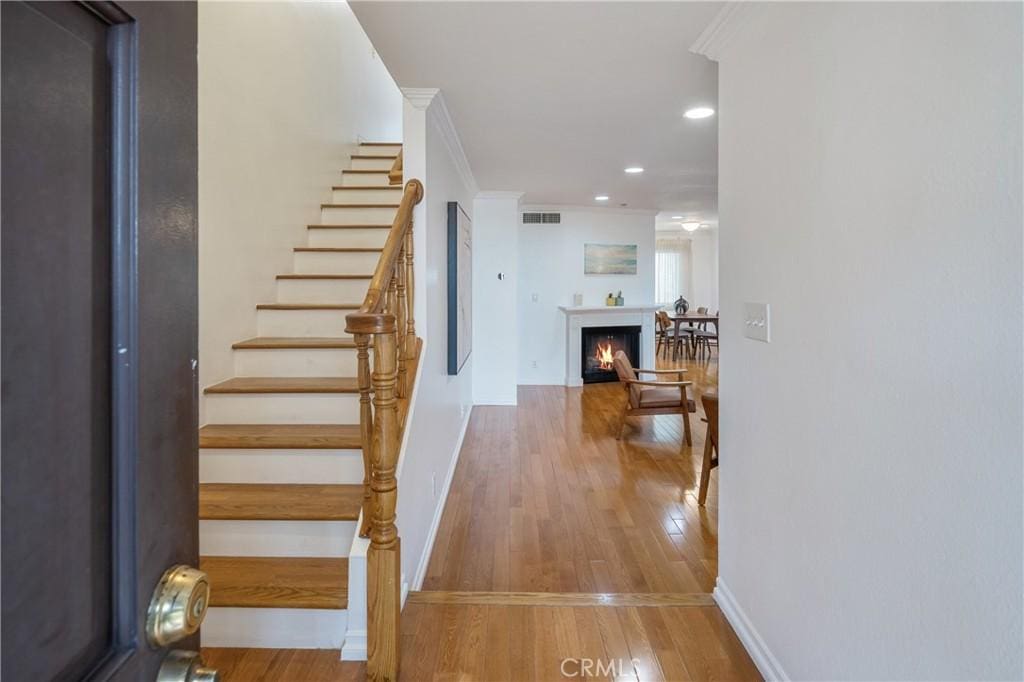 foyer entrance featuring ornamental molding and light hardwood / wood-style flooring