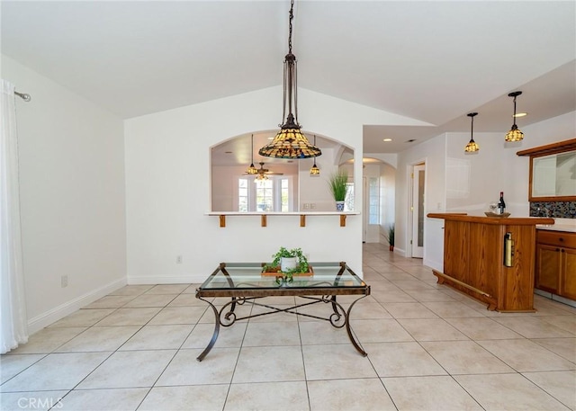 tiled dining space featuring vaulted ceiling