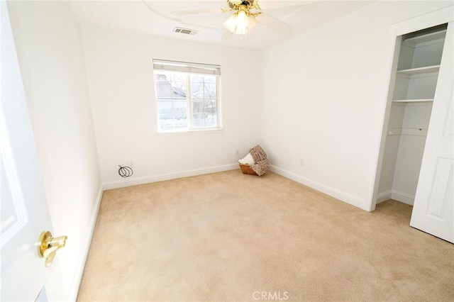 unfurnished bedroom with light colored carpet, ceiling fan, and a closet