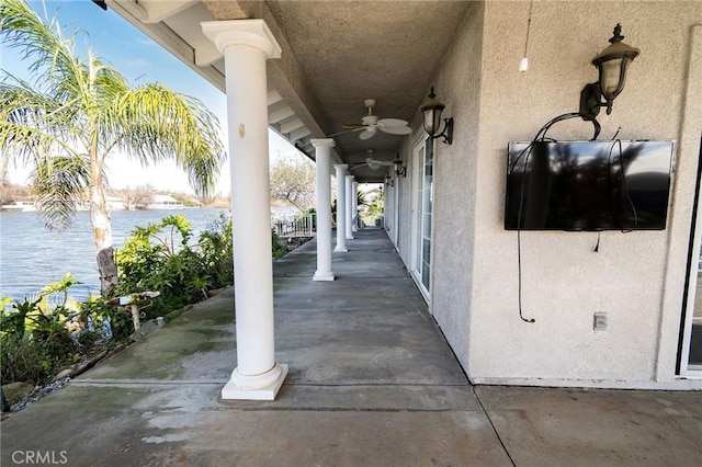 view of patio / terrace featuring ceiling fan and a water view