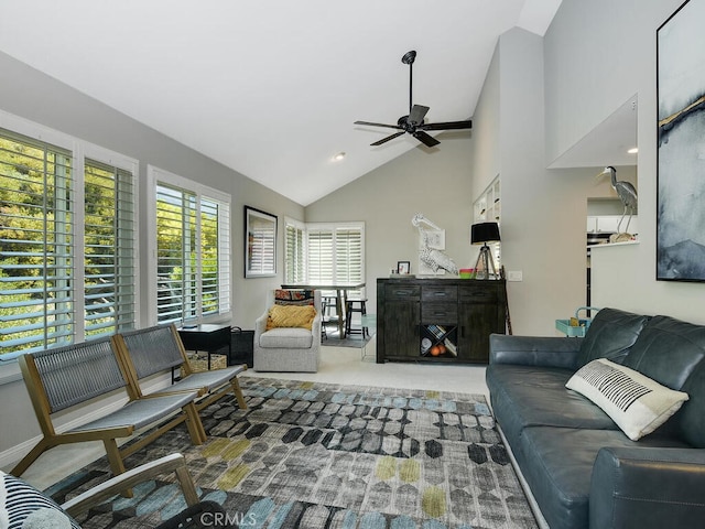 carpeted living room with ceiling fan and high vaulted ceiling