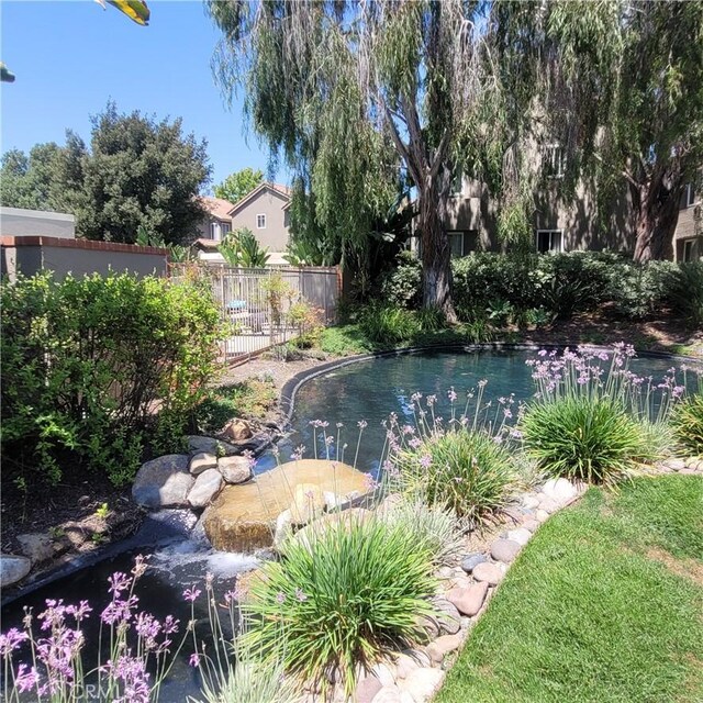 930 Via Mil Cumbres Unit 88, Solana Beach, CA 92075 - view of swimming pool with a garden pond and fence