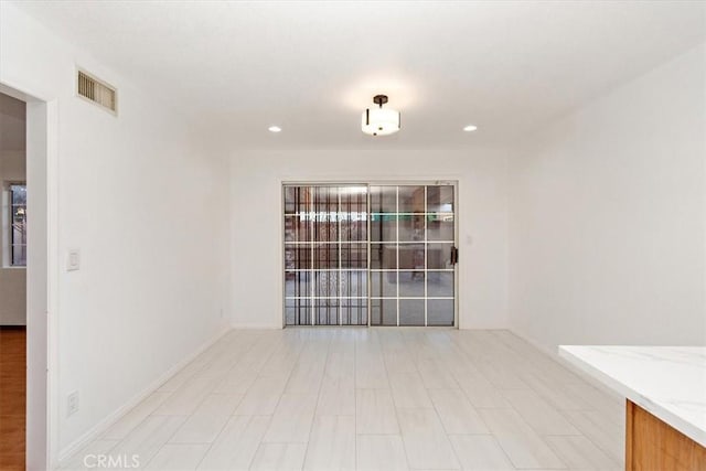 spare room with recessed lighting, visible vents, and baseboards