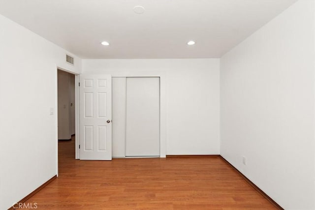 unfurnished bedroom with recessed lighting, a closet, visible vents, light wood-style flooring, and baseboards