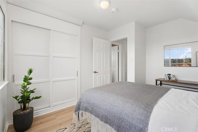 bedroom with vaulted ceiling and light hardwood / wood-style flooring