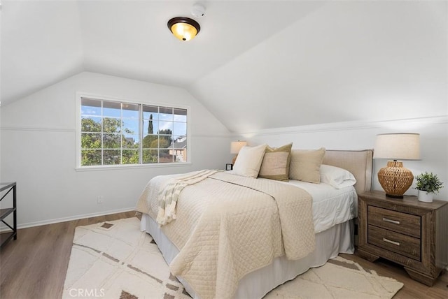 bedroom featuring lofted ceiling and light hardwood / wood-style flooring