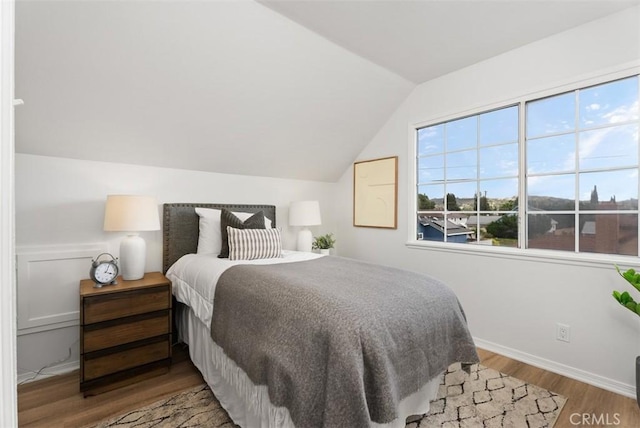 bedroom featuring hardwood / wood-style flooring and vaulted ceiling