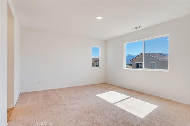 carpeted spare room featuring visible vents and baseboards