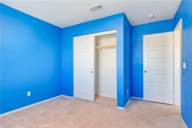 unfurnished bedroom with carpet, visible vents, a closet, and baseboards