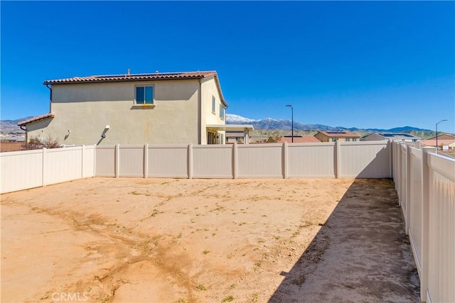 view of yard featuring a mountain view and a fenced backyard