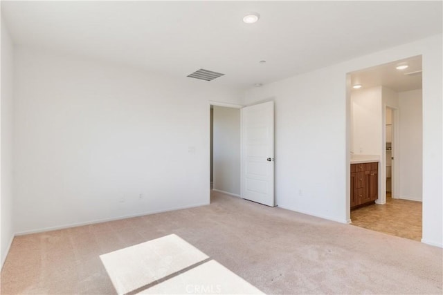 spare room with recessed lighting, visible vents, light carpet, and baseboards