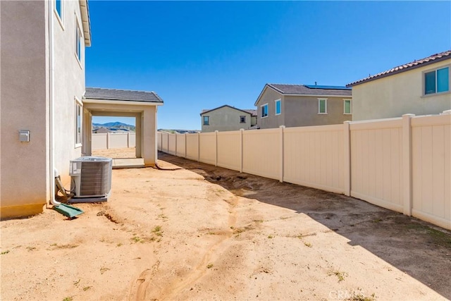 view of yard with central AC unit and a fenced backyard