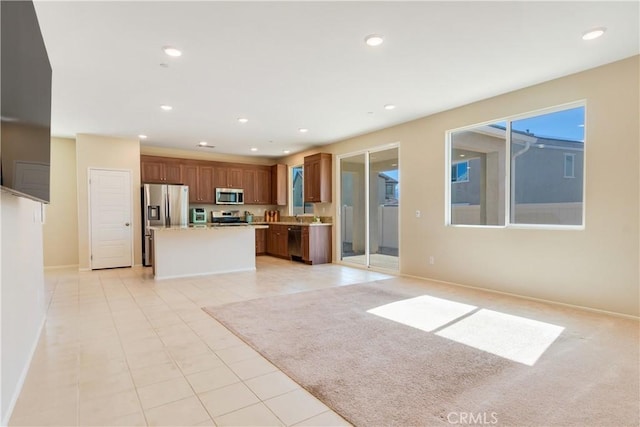 kitchen with a center island, open floor plan, light countertops, recessed lighting, and stainless steel appliances