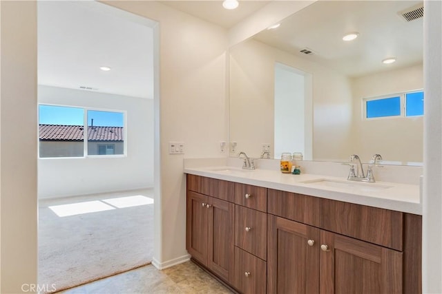 bathroom with double vanity, visible vents, and a sink