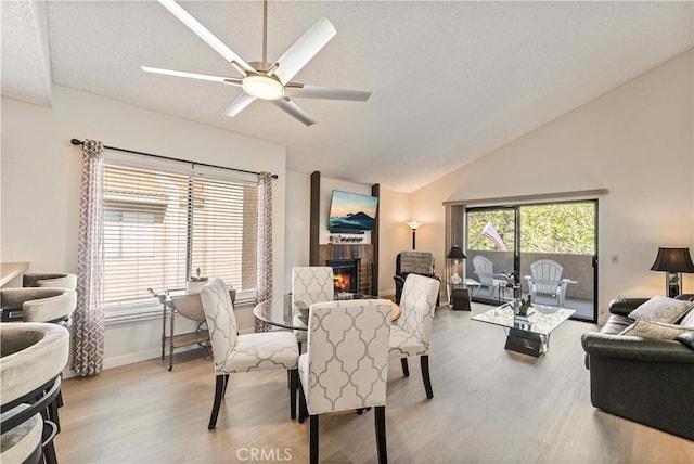 769 Birchpark Cir Unit 207, Thousand Oaks, CA 91360 - dining area with lofted ceiling, wood finished floors, a brick fireplace, a ceiling fan, and baseboards