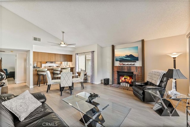 769 Birchpark Cir Unit 207, Thousand Oaks, CA 91360 - living area with a brick fireplace, lofted ceiling, baseboards, a ceiling fan, and a textured ceiling
