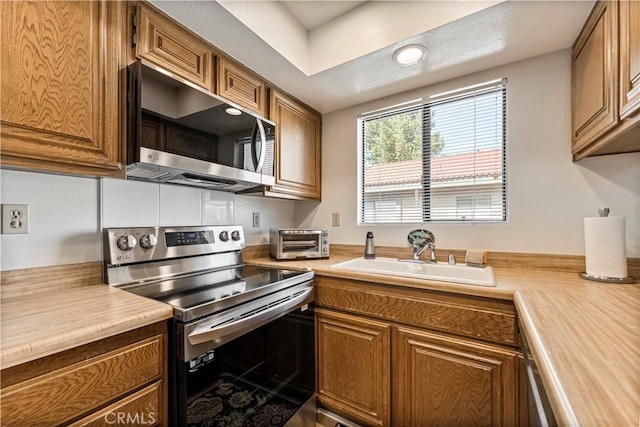 769 Birchpark Cir Unit 207, Thousand Oaks, CA 91360 - kitchen with stainless steel appliances, a sink, light countertops, brown cabinetry, and recessed lighting