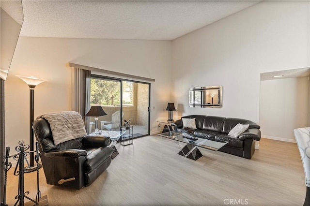 769 Birchpark Cir Unit 207, Thousand Oaks, CA 91360 - living room featuring wood finished floors, high vaulted ceiling, baseboards, and a textured ceiling