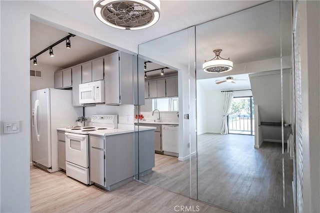 2323 Huntington St Unit 907, Huntington Beach, CA 92648 - kitchen featuring light wood finished floors, rail lighting, a ceiling fan, white appliances, and gray cabinetry