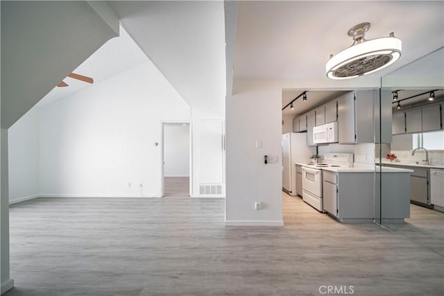 2323 Huntington St Unit 907, Huntington Beach, CA 92648 - kitchen with gray cabinets, white appliances, rail lighting, and open floor plan