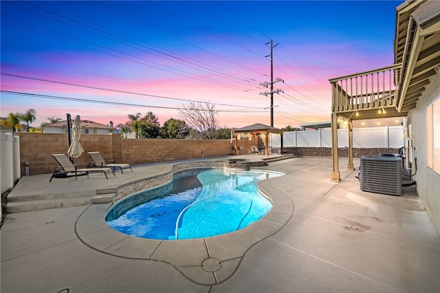 pool at dusk featuring central AC, a patio, and a gazebo