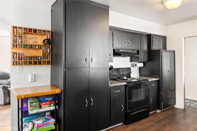 kitchen featuring black range with electric stovetop, dark hardwood / wood-style floors, and stainless steel fridge