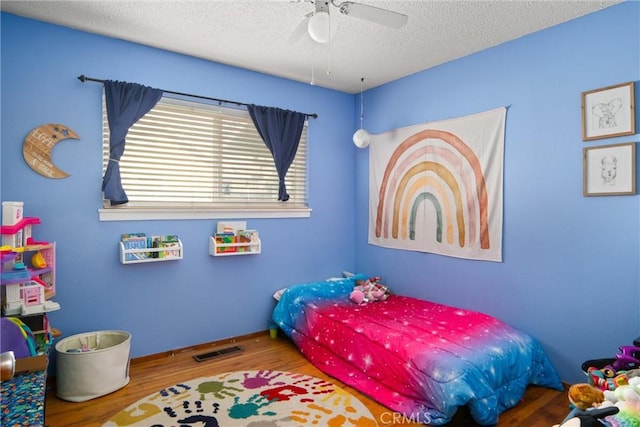 bedroom with wood-type flooring, ceiling fan, and a textured ceiling