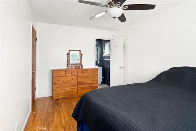 bedroom featuring ceiling fan, a textured ceiling, and light wood-type flooring