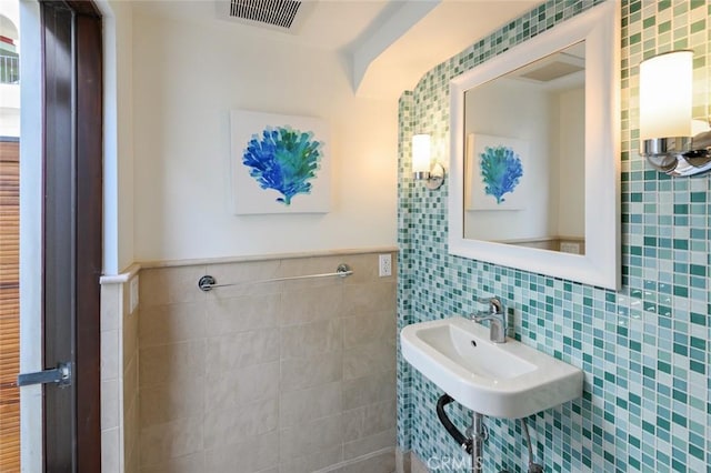 bathroom with sink and tile walls