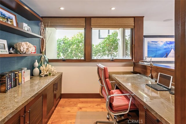 home office featuring light wood-type flooring and built in desk