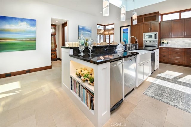 kitchen featuring stainless steel appliances, an island with sink, decorative backsplash, pendant lighting, and light tile patterned floors