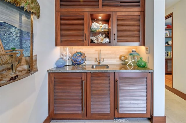 bar featuring decorative backsplash and sink