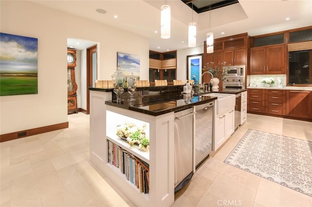 kitchen with light tile patterned floors, sink, stainless steel appliances, hanging light fixtures, and an island with sink