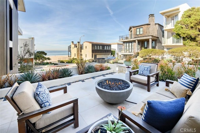 view of patio / terrace with a water view and an outdoor living space with a fire pit