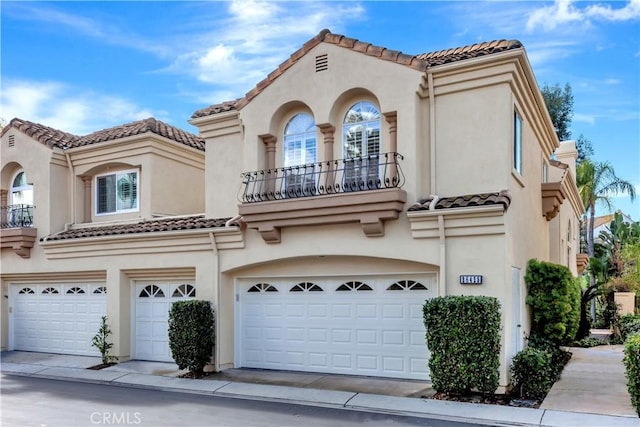 mediterranean / spanish-style home featuring a garage and a balcony